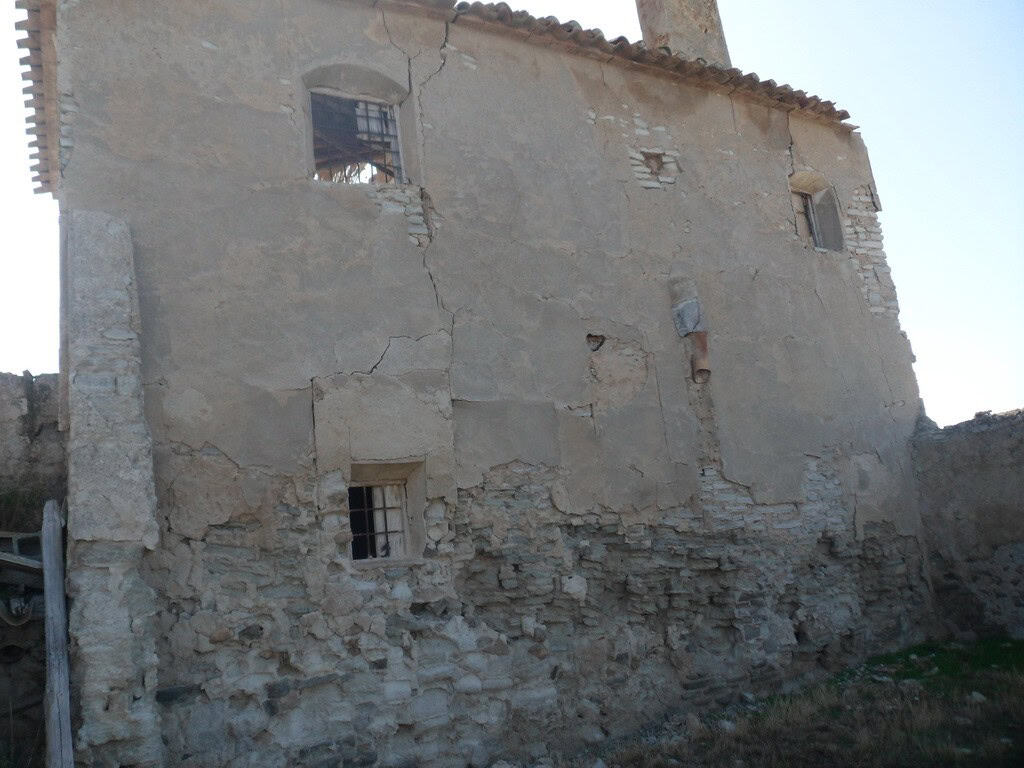 Rural property in Venta del Peral, Granada, featuring an old, rustic building with weathered walls a.