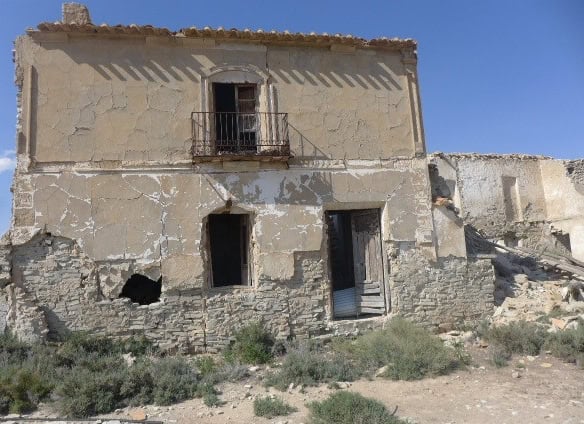 Old rural house in Venta del Peral, Granada, with weathered walls and a small balcony.