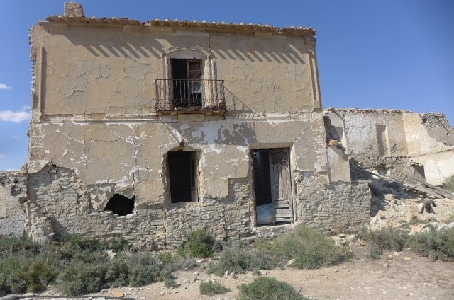 Old rural house in Venta del Peral, Granada, with weathered walls and a small balcony.