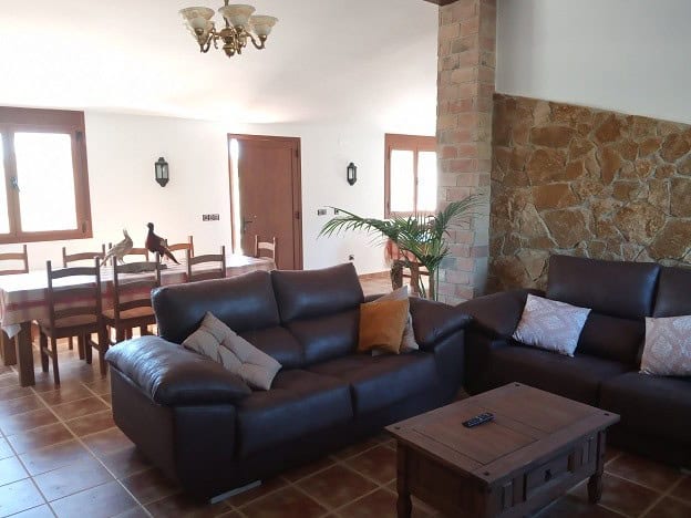 Spacious living room with leather sofas, wooden furniture, and natural light in a country estate in.