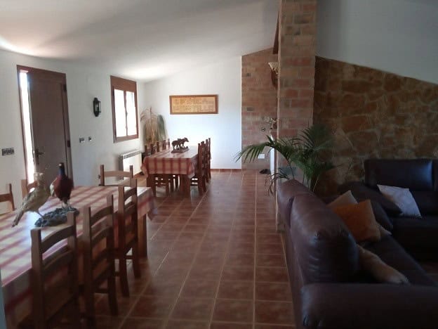 Spacious living and dining area with rustic decor in a country estate located in Fontanar, Jaen.
