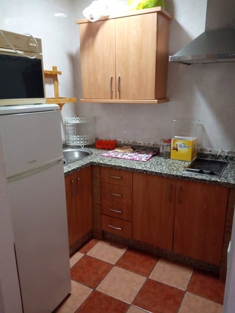 Compact kitchen with wooden cabinets in Gor, Granada.