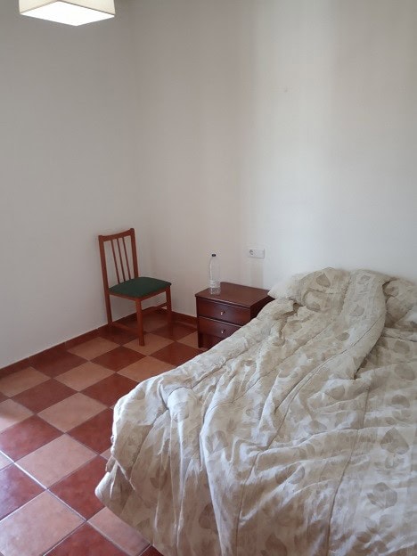 Bedroom with bed, nightstand, and chair in Gor, Granada.