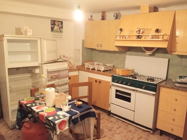 Charming kitchen of a village property in Hinojares, Jaen, featuring wooden cabinets, a stove, and c.