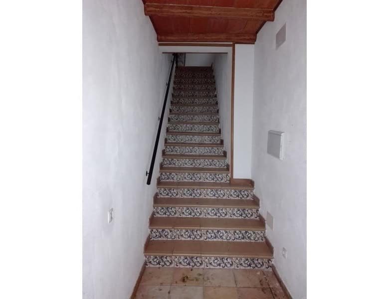 Commercial property staircase in Seron, Almeria with decorative tiles and white walls.