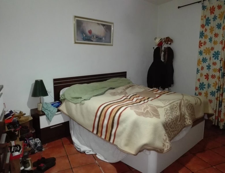 Comfortable bedroom with a double bed, bedside table, and colorful curtains in Seron, Almeria.