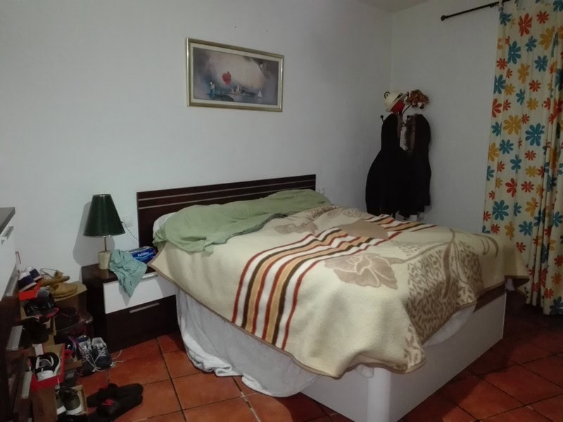 Comfortable bedroom with a double bed, bedside table, and colorful curtains in Seron, Almeria.
