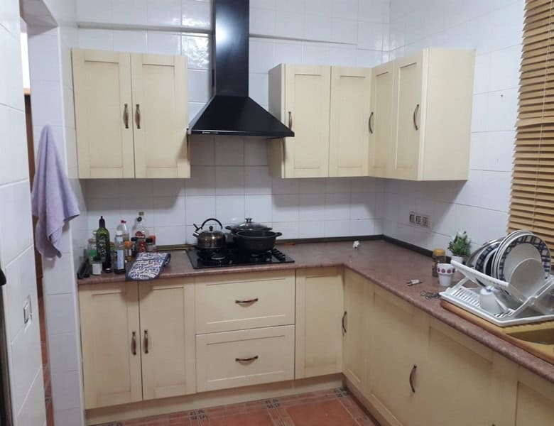 Charming kitchen of a town house in Seron, Almeria, featuring cream cabinets and modern appliances.