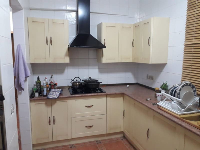 Charming kitchen of a town house in Seron, Almeria, featuring cream cabinets and modern appliances.