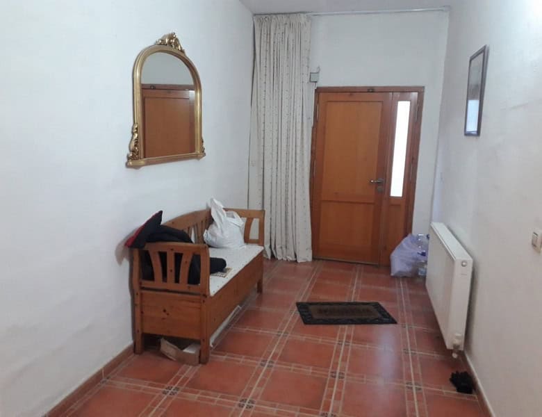 Charming town house interior in Seron, Almeria, featuring a cozy wooden bench and classic decor.