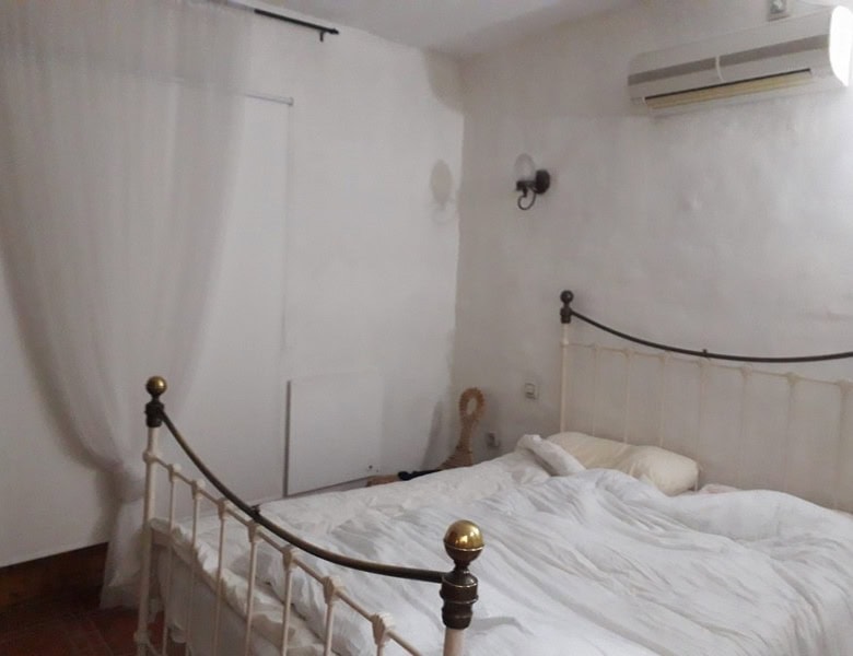 Charming town house bedroom in Seron, Almeria with white walls, air conditioning, and cozy bedding.