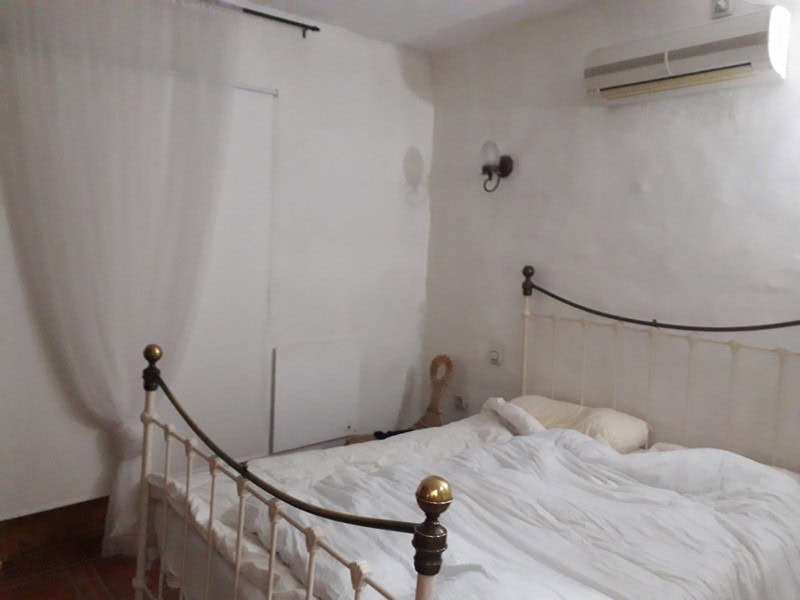 Charming town house bedroom in Seron, Almeria with white walls, air conditioning, and cozy bedding.