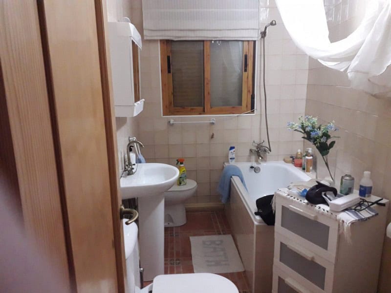 Charming bathroom in a town house in Seron, Almeria, featuring a bathtub, sink, and natural light fr.