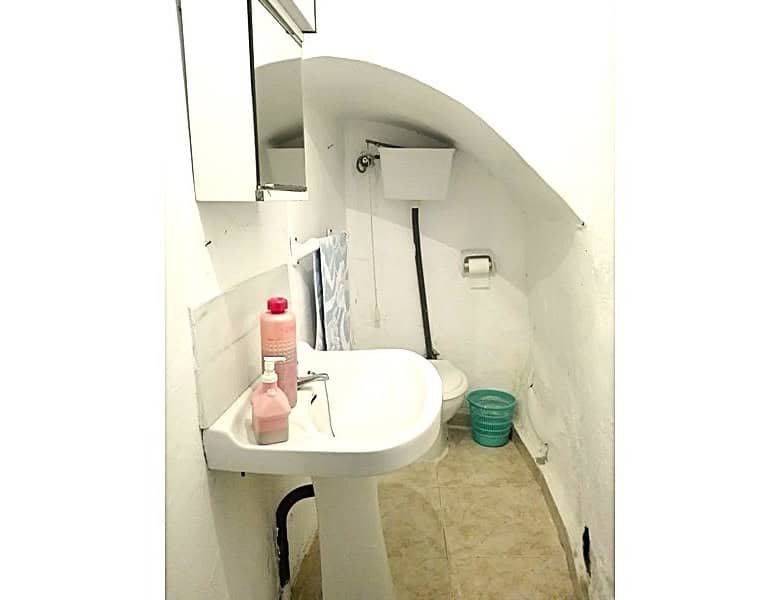 Charming village property bathroom in Somontin, Almeria with white walls, small sink, and basic amen.