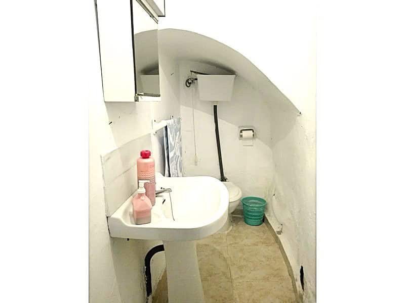 Charming village property bathroom in Somontin, Almeria with white walls, small sink, and basic amen.