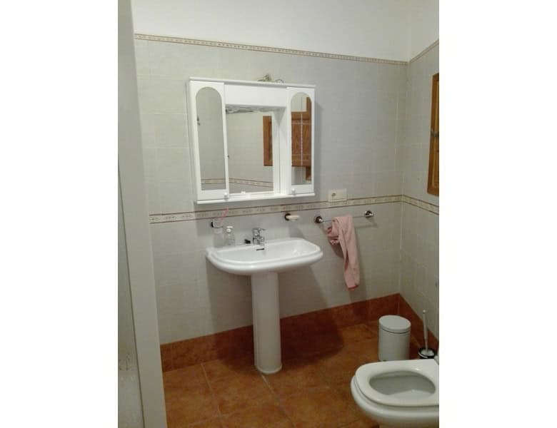 Charming bathroom in a village property in Seron, Almeria, featuring a white sink, mirror, and basic.