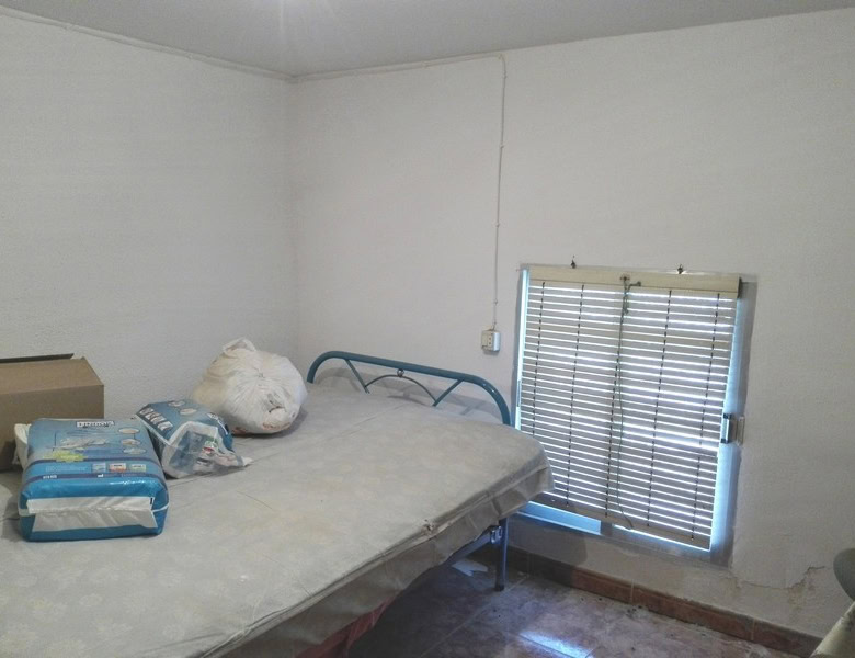 Charming village property in Seron, Almeria, featuring a simple bedroom with a metal bed frame and w.