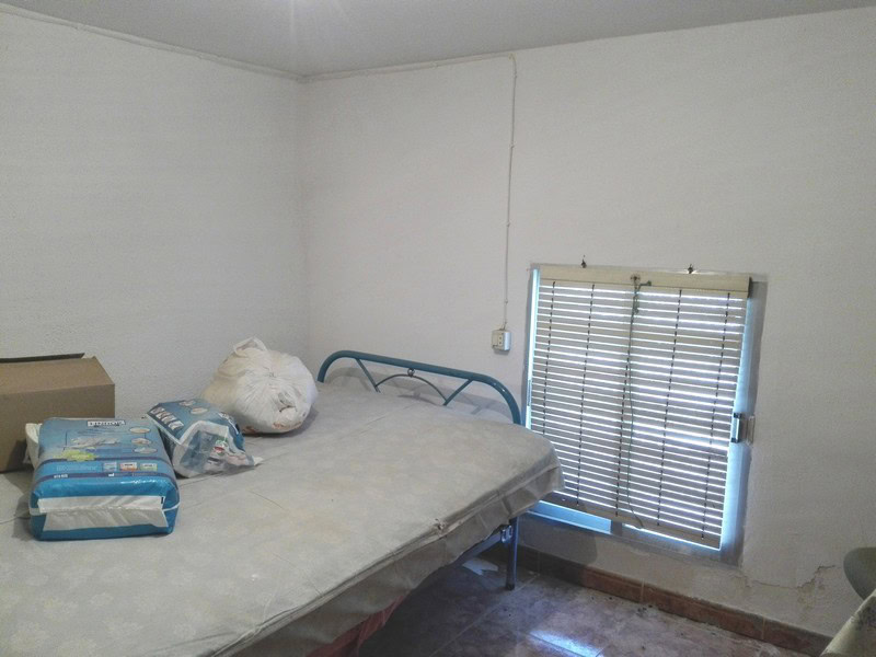 Charming village property in Seron, Almeria, featuring a simple bedroom with a metal bed frame and w.