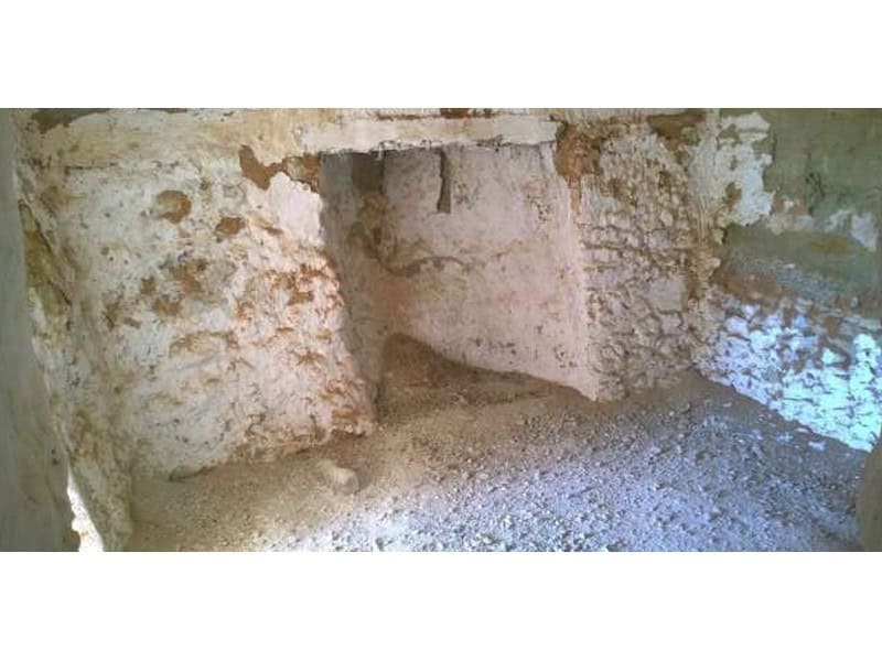 Cave house interior in Baza, Granada, showcasing traditional rock construction.