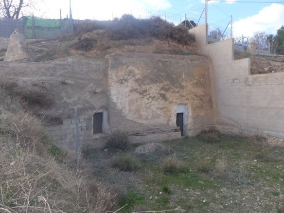 Cave house nestled in Baza, Granada, with natural rock walls and rustic charm.