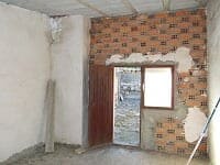 Interior view of a rustic village property in Seron, Almeria, showing brick walls and a small window.