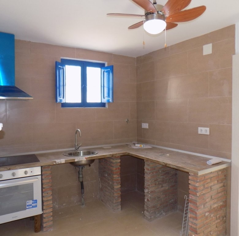 Charming kitchen in a village property in Sierro, Almeria with modern appliances and rustic brick ac.