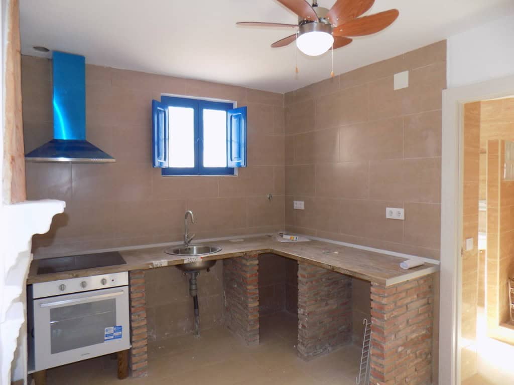 Charming kitchen in a village property in Sierro, Almeria with modern appliances and rustic brick ac.