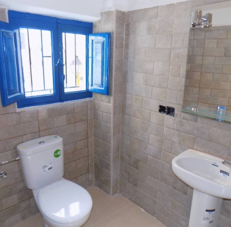 Village property bathroom in Sierro, Almeria with blue window shutters and modern fixtures.