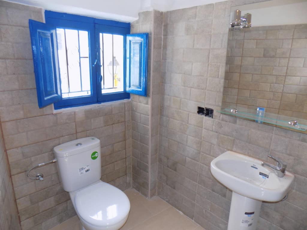 Village property bathroom in Sierro, Almeria with blue window shutters and modern fixtures.