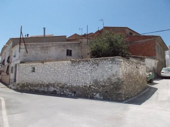 Village property for sale in Tijola, Almeria, with traditional stone walls and surrounding homes.