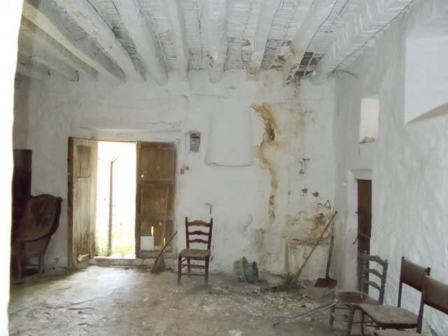 Village property interior with rustic charm in Tijola, Almeria, featuring exposed beams and weathere.