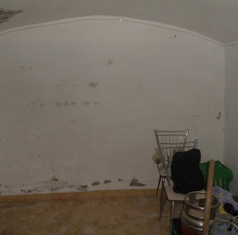 Cave house interior with simple furnishings in Guadix, Granada, showcasing traditional cave dwelling.