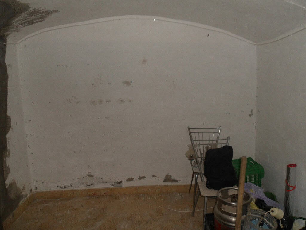 Cave house interior with simple furnishings in Guadix, Granada, showcasing traditional cave dwelling.