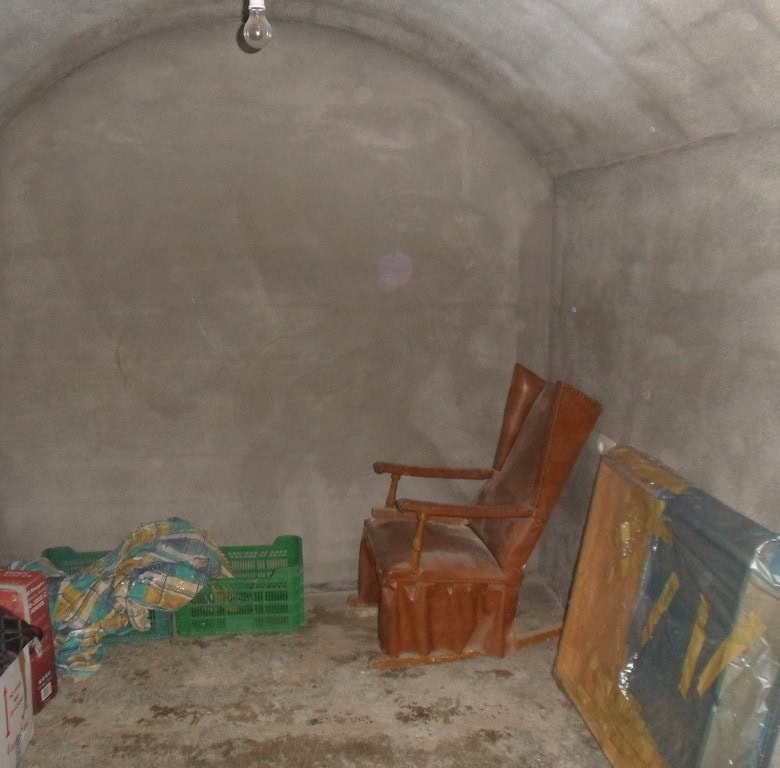 Cave house interior with rustic wooden chairs and storage boxes in Guadix, Granada. Unique undergrou.