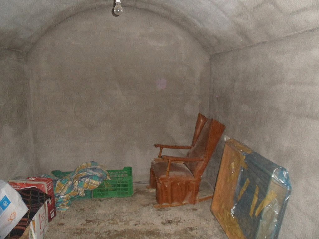 Cave house interior with rustic wooden chairs and storage boxes in Guadix, Granada. Unique undergrou.