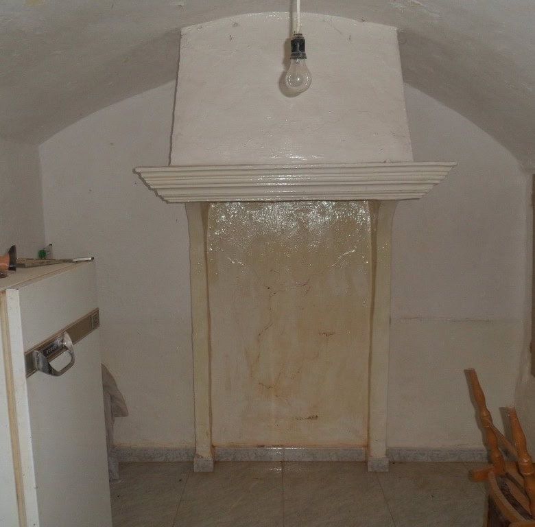 Charming cave house interior in Guadix, Granada, featuring a rustic fireplace and cozy living space.