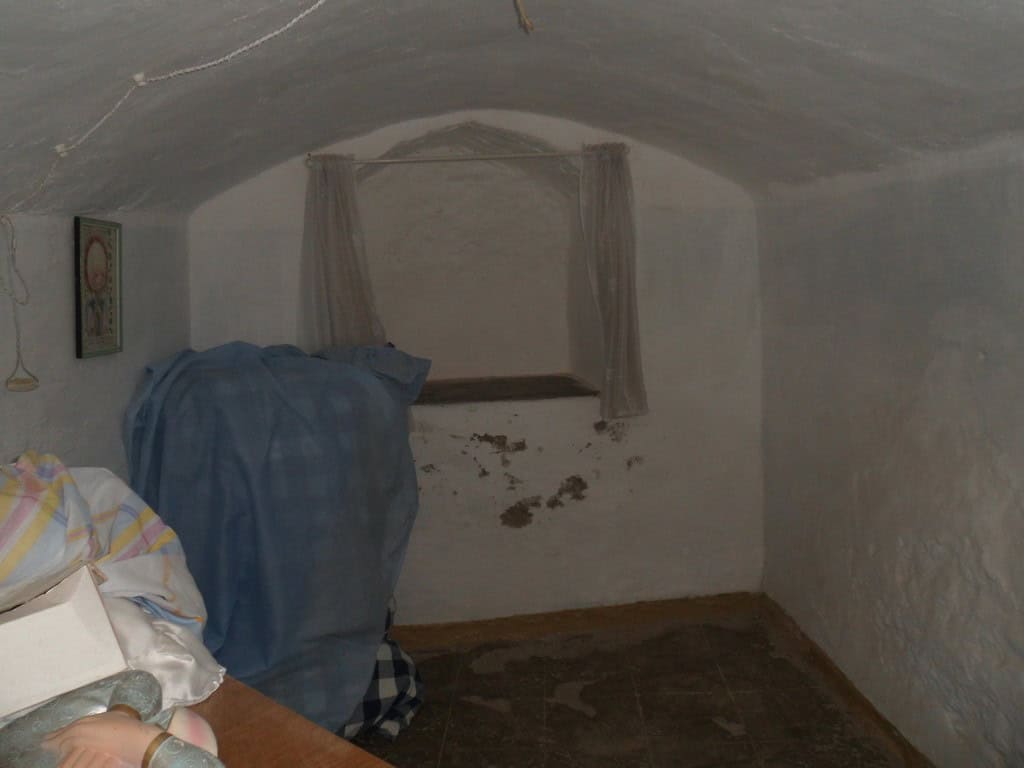 Unique cave house interior in Guadix, Granada, with whitewashed walls and small window.