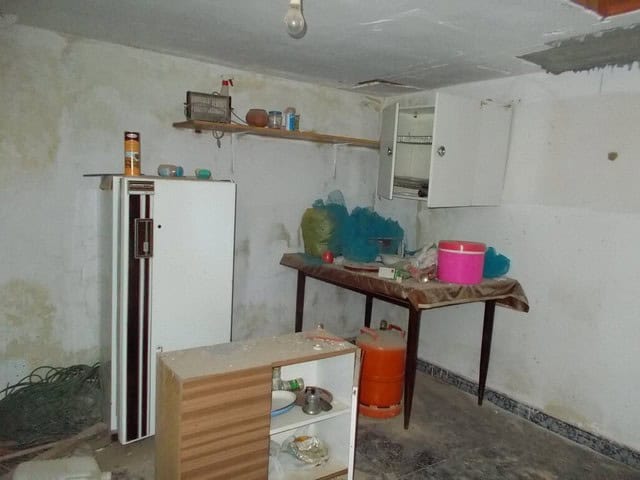 Interior of a rustic rural property in Seron, Almeria, showing basic kitchen setup and storage.