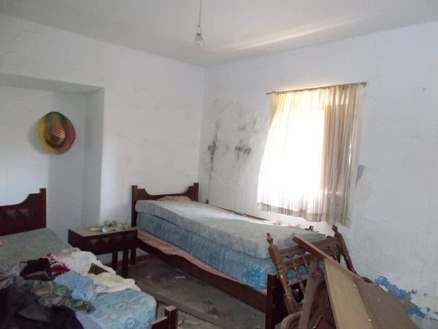 Rundal property interior with two beds and worn walls in Seron, Almeria.