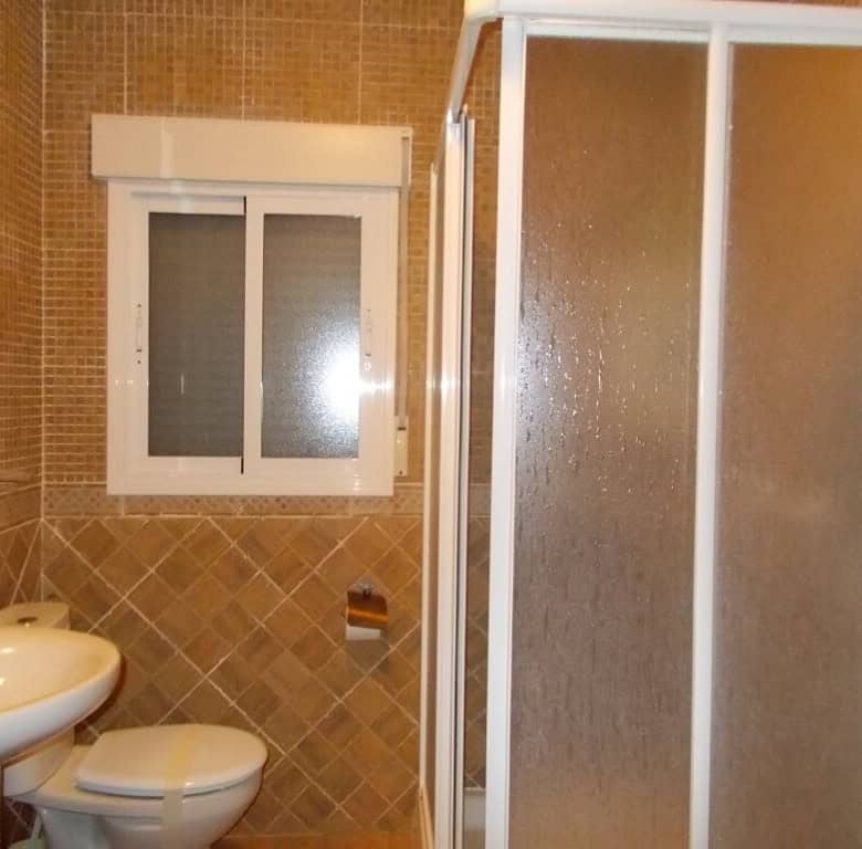 Cozy bathroom in a village property in Seron, Almeria, featuring a shower, toilet, and sink with til.