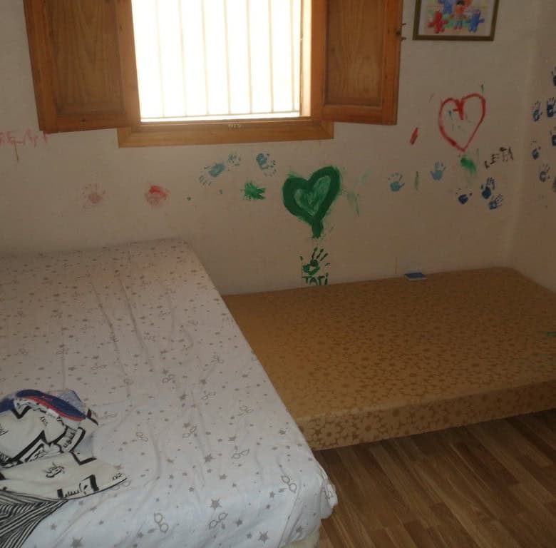 Farm property in Zujar, Granada with two bedrooms and colorful wall art, ideal for rural living.