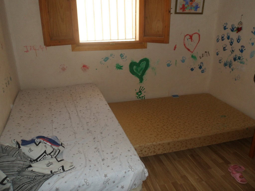 Farm property in Zujar, Granada with two bedrooms and colorful wall art, ideal for rural living.