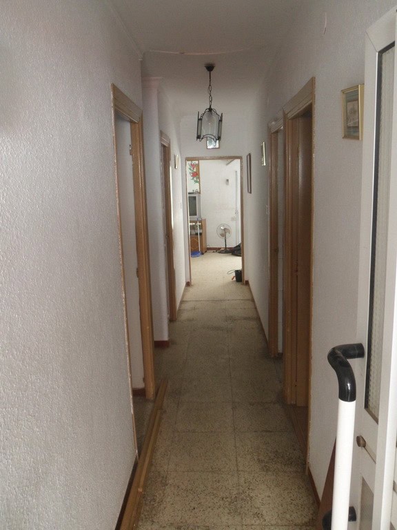 Charming interior hallway of a town house in Freila, Granada, featuring wooden door frames and a sim.