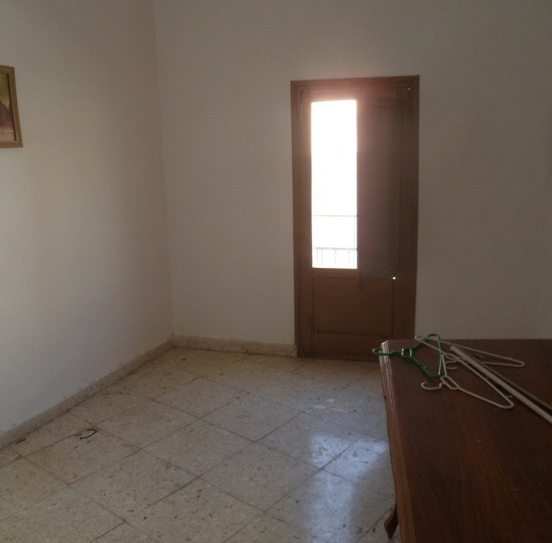 Charming interior of a town house in Freila, Granada, featuring a simple room with religious artwork.