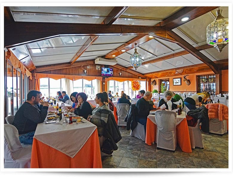 Restaurant interior with diners in Baza, Granada, showcasing a cozy dining atmosphere.