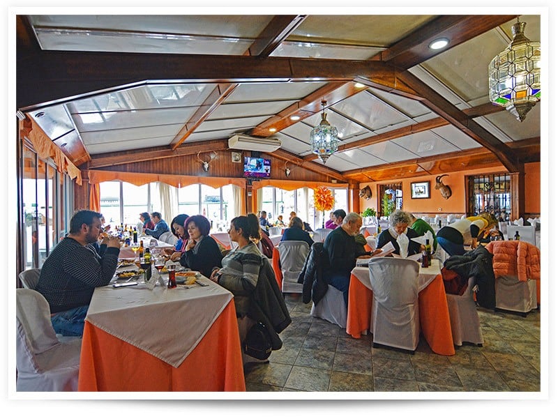 Restaurant interior with diners in Baza, Granada, showcasing a cozy dining atmosphere.