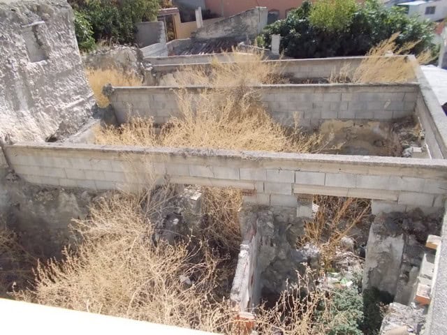Abandoned village property in Lucar, Almeria featuring crumbling walls and wild, dry vegetation.