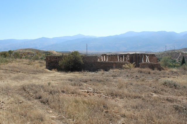 Ancient rural property ruins in Tijola, Almeria, surrounded by dry landscape and mountains in the ba.