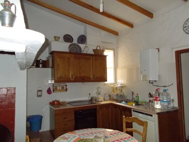 Village Property Kitchen in Tijola, Almeria with rustic wooden cabinets and traditional decor.