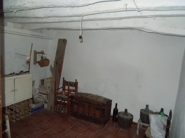 Interior view of a rustic village property in Tijola, Almeria, showcasing simple furnishings and tra.